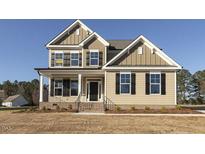 Two-story house with beige siding, black shutters, and a front porch at 181 Sage Ln, Four Oaks, NC 27524