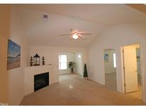 Bright living room with vaulted ceiling, fireplace, and neutral carpeting at 2530 Friedland Pl # 104, Raleigh, NC 27617