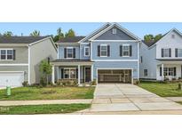 Two-story home with blue siding, two-car garage, and landscaped lawn at 1013 Aspen View Dr, Raleigh, NC 27610