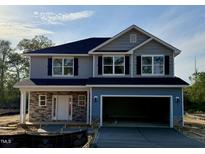 Two-story home featuring stone accents, a two car garage and black shutters on the windows at 203 Lake Edge Dr, Lillington, NC 27546