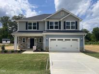 Charming two-story home with gray and blue siding, black shutters, and a two-car garage at 203 Lake Edge Dr, Lillington, NC 27546