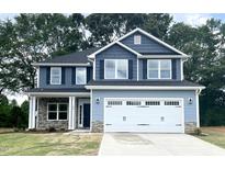 Two-story house with gray siding, stone accents, and a two-car garage at 217 Lake Edge Dr, Lillington, NC 27546