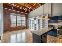 Open living room with exposed brick and hardwood floors at 500 N Duke St # 55-306, Durham, NC 27701