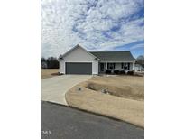 Ranch-style home with gray double garage and landscaped yard at 55 Fall Bridge Cir, Benson, NC 27504