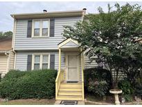 Gray two-story townhome with yellow steps and landscaping at 6548 English Oaks Dr, Raleigh, NC 27615