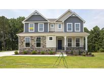 Two-story home with stone and siding accents, featuring a welcoming front porch at 72 Demascus Way, Four Oaks, NC 27524