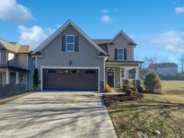Two-story house with gray siding, brown garage door, and landscaped yard at 917 Palm Ct, Mebane, NC 27302