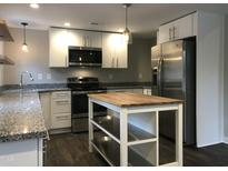 Modern kitchen with stainless steel appliances, granite counters, and a functional center island at 1312 Fay St, Durham, NC 27701