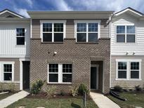Two-story townhome with brick and siding exterior, featuring multiple windows and a front yard at 2054 Glen Crossing Dr, Durham, NC 27704
