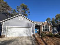 Gray sided house with white garage door and brick accents at 2106 Pathway Dr, Chapel Hill, NC 27516