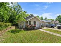 Charming single-story home with a well-manicured lawn and vibrant rose bushes enhancing curb appeal at 2612 Ashe St, Durham, NC 27703