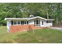 Ranch home with brick and siding exterior, spacious yard, and mature trees at 5617 Laurel Crest Dr, Durham, NC 27712