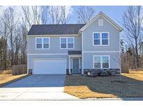 Two-story house with gray siding, a white garage door, and a landscaped yard at 601 Joe Gibson Dr, Gibsonville, NC 27249