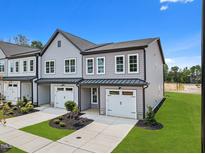 Beautiful two-story townhome with gray siding, white trim, manicured lawn and two-car garage on a sunny day at 712 Jamescroft Way # 26, Rolesville, NC 27571