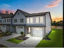 Charming new construction townhome boasts a one-car garage and beautiful gray siding at 712 Jamescroft Way # 26, Rolesville, NC 27571