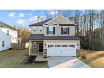 Charming two-story home with stone accents, a two-car garage and well-maintained landscaping at 130 Buffaloe Grove Ln, Garner, NC 27529
