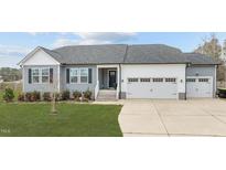 Charming single-story home with a two-car garage, well-manicured lawn, and beautifully landscaped front yard at 173 Pine Meadow Way, Middlesex, NC 27557