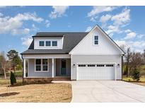 Charming two-story home with gray siding, white trim, a two-car garage, and a manicured front lawn at 57 Nottoway Ln, Wendell, NC 27591