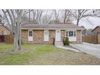 Brick ranch house with a front yard, driveway, and wooden fence at 915 Da Vinci St, Durham, NC 27704