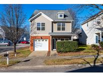 Two-story townhome with brick accents and attached garage at 105 Danesway Dr, Holly Springs, NC 27540