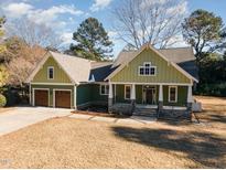 Craftsman style home with green siding, two-car garage, and stone accents at 113 Meadowglades Ln, Cary, NC 27518