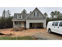 Charming home under construction with gray siding, dark shutters, and an attached two car garage at 214 Rye Way, Wendell, NC 27591