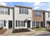 Two-story townhome with light-colored siding, brick accents, and a welcoming front porch at 3 Cheltenham Dr, Clayton, NC 27520