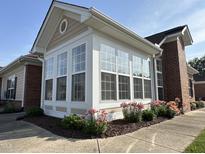 Bright sunroom addition with large windows and brick exterior and colorful landscaping at 4712 Fox Fern Ln, Raleigh, NC 27604