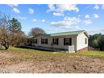 Single-story home with green roof and deck at 754 Firestone Ln, Sanford, NC 27330