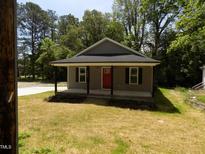 Charming single-story home boasts a welcoming front porch and fresh, neutral-toned siding at 104 Halifax Rd, Louisburg, NC 27549