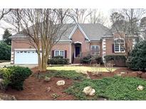 Charming brick home with a well-manicured front yard and attached two-car garage at 1508 High Holly Ln, Raleigh, NC 27614