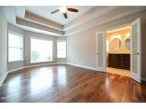 Spacious main bedroom boasting hardwood floors and a tray ceiling leading to ensuite bathroom at 1508 Woods Creek Dr, Garner, NC 27529