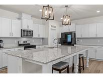 A spacious kitchen features granite counters, stainless appliances, pendant lighting, and stylish white cabinetry at 168 Begonia St, Angier, NC 27501