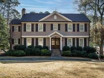 Charming two-story home featuring a manicured lawn and neutral siding with black shutters and a welcoming front porch at 505 Annandale Dr, Cary, NC 27511