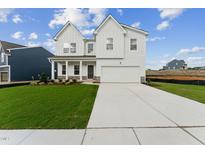 Two-story white farmhouse-style home with a large front yard and driveway at 517 Marthas View Way, Wake Forest, NC 27587