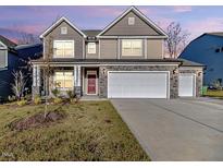 Two-story house with a two-car garage, red door, and landscaping at 605 Hampton Crest Ct, Fuquay Varina, NC 27526