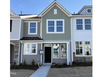 Charming two-story townhome with a modern design, a welcoming entrance, and newly installed landscaping at 6332 Granite Quarry Dr, Raleigh, NC 27610