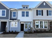 Charming townhome featuring a mix of light-colored siding, stone accents, and well-manicured landscaping at 6336 Granite Quarry Dr, Raleigh, NC 27610