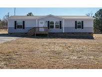 Single-wide manufactured home with gray siding, wood deck, and landscaping at 6545 Old Jefferson Davis Hwy, Cameron, NC 28326