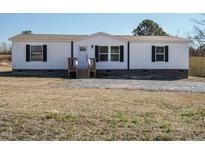 White single-wide manufactured home with black shutters and a wooden deck at 6567 Old Jefferson Davis Hwy, Cameron, NC 28326