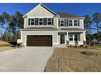 Two-story house with gray siding, brown garage door, and landscaping at 118 Sourgum Ct, Zebulon, NC 27597