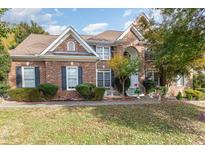 Brick home with landscaping, two-car garage, and a charming front porch at 12408 Canolder St, Raleigh, NC 27614