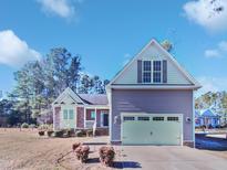 Two-story house with a large garage and landscaping at 1813 Ferrell Meadows Dr, Zebulon, NC 27597