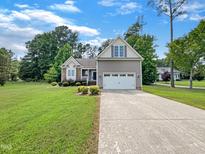 Charming single-Gathering home featuring a two-car garage, manicured lawn, and beautiful landscaping at 1813 Ferrell Meadows Dr, Zebulon, NC 27597