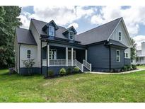 Beautiful home with a well-manicured lawn, lush trees, and stylish gray wood siding at 20 Tamaran Ct, Spring Hope, NC 27882