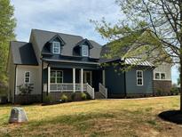 Charming two-story home featuring a welcoming front porch, stylish blue siding, and a well-manicured lawn at 20 Tamaran Ct, Spring Hope, NC 27882