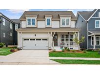 Charming two-story home featuring a covered porch, a two-car garage, and manicured landscaping at 224 Wash Hollow Dr, Wendell, NC 27591