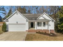 White house with brick accents, a two-car garage, and a covered front porch at 2773 Clifton Avenue, Creedmoor, NC 27522