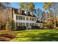 Two-story white house with green shutters, a manicured lawn, and mature trees at 3 Acornridge Ct, Durham, NC 27707