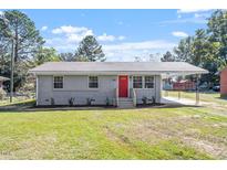 Newly renovated single-story home with gray siding and a red front door at 609 E Cockrell St, Nashville, NC 27856